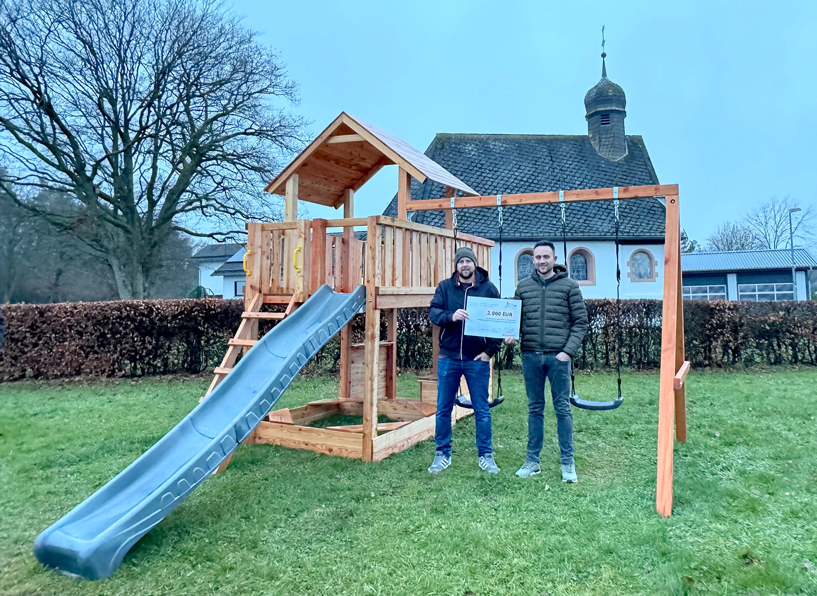 Den symbolischen Fördersscheck nahmen Mario Becker (l.) und Björn Stoff vom Kapellenverein Kerperscheid entgegen.