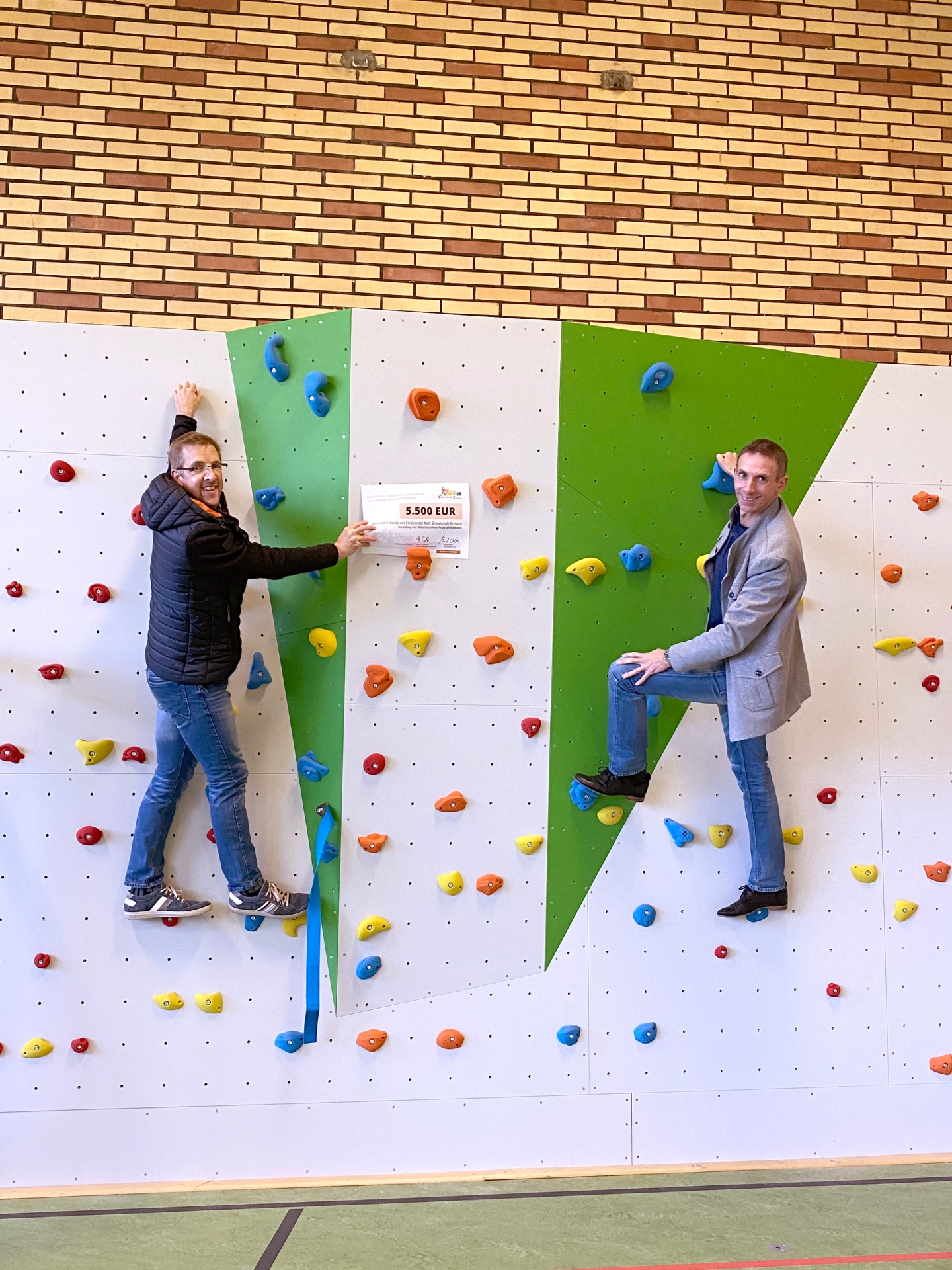 Stefan Franke vom Förderverein der Grundschule Dreiborn und der Geschäftsführer der Bürgerstiftung Schleiden, Marcel Wolter, testeten die Boulderwand in der Dreiborner Turnhalle.
