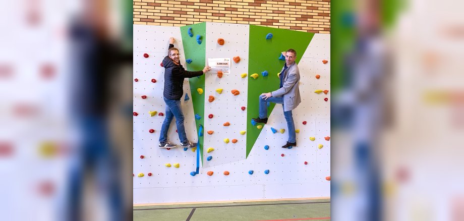 Stefan Franke vom Förderverein der Grundschule Dreiborn und der Geschäftsführer der Bürgerstiftung Schleiden, Marcel Wolter, testeten die Boulderwand in der Dreiborner Turnhalle.