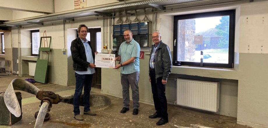 Stellvertretender Kuratoriumsvorsitzender Bernd Kehren (links) überreichte den Förderscheck der Bürgerstiftung Schleiden an den 1. Vorsitzenden der AG Luftkriegsgeschichte, Frank Güth. Projektleiter Fritz Wiebel (rechts) von der Firma TodaySystems, verantwortlich für die bauliche Umsetzung der Ausstellung war bei der Scheckübergabe ebenfalls vor Ort.