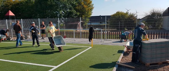 Ehrenamtliche Arbeiten am Kunstrasenplatz in Dreiborn.