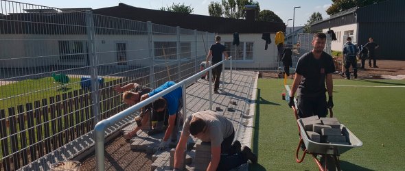 Ehrenamtliche Arbeiten am Kunstrasenplatz in Dreiborn.