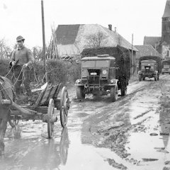 SA Schleiden, Bildsammlung: Während ein Militärfahrzeug nach dem Anderen durch Dreiborn rollt, fährt Bauer Bernhard Wolter mit seinem Fuhrwerk aufs Feld, 1954 (Urheberin: LEONIE SAUERBIER).