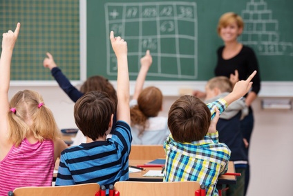 Schüler in der Grundschule zeigen auf Schüler in der Grundschule zeigen auf