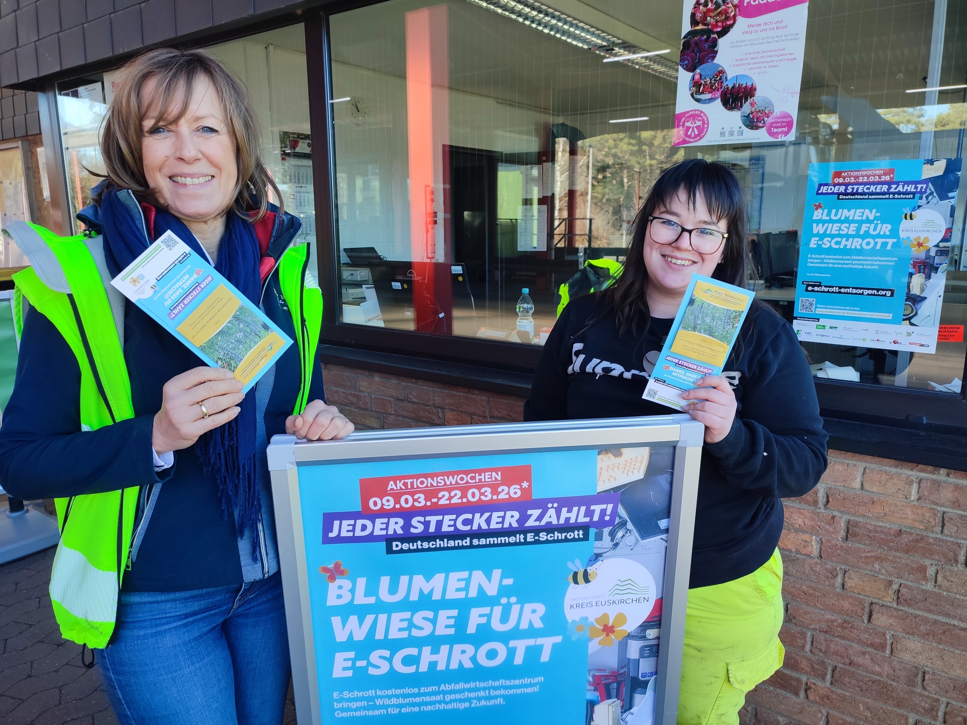 Vom 9. März bis 21. März 2026 werden am Wiegehaus des Abfallwirtschaftszentrum in Mechernich wieder bei Abgabe von Elektroaltgeräten regionale Blumensamen ausgeteilt. Hier von Nicole Peters (l.) und Brigitte Ohlert (r.).