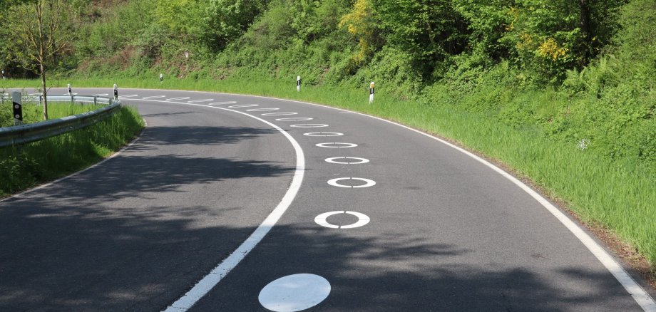 Die weißen Kreise zeigen eine sichere Fahrlinie an. Wer sich daran hält, kommt nicht in den Gegenverkehr und hält genügend Abstand zu entgegenkommenden Fahrzeugen. Das Foto stammt vom Pilotprojekt 2023 an der Panoramastraße im Kreis Düren. Auf der L234 bei Bad Münstereifel sollen die Kreise Ende Mai / Anfang Juni aufgebracht werden. Die weißen Kreise zeigen eine sichere Fahrlinie an. Wer sich daran hält, kommt nicht in den Gegenverkehr und hält genügend Abstand zu entgegenkommenden Fahrzeugen. Das Foto stammt vom Pilotprojekt 2023 an der Panoramastraße im Kreis Düren. Auf der L234 bei Bad Münstereifel sollen die Kreise Ende Mai / Anfang Juni aufgebracht werden.