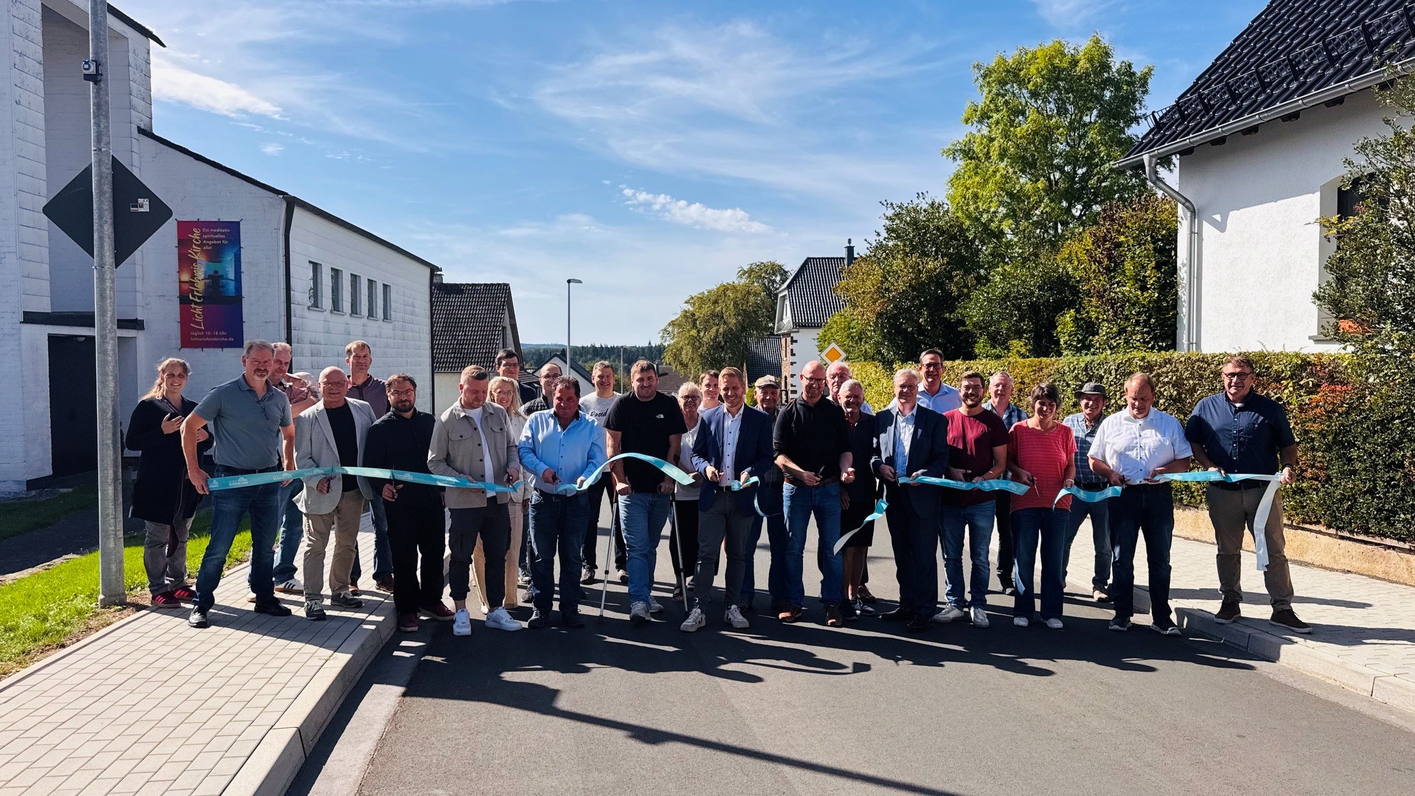 Mit dem obligatorischen „Scherenschnitt“ wurde die neue Straße in Schleiden-Scheuren jetzt offiziell für den Verkehr freigegeben.