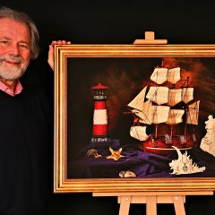 Foto von Michael Usadel und einem seiner Fotos bei einer Ausstellung. 