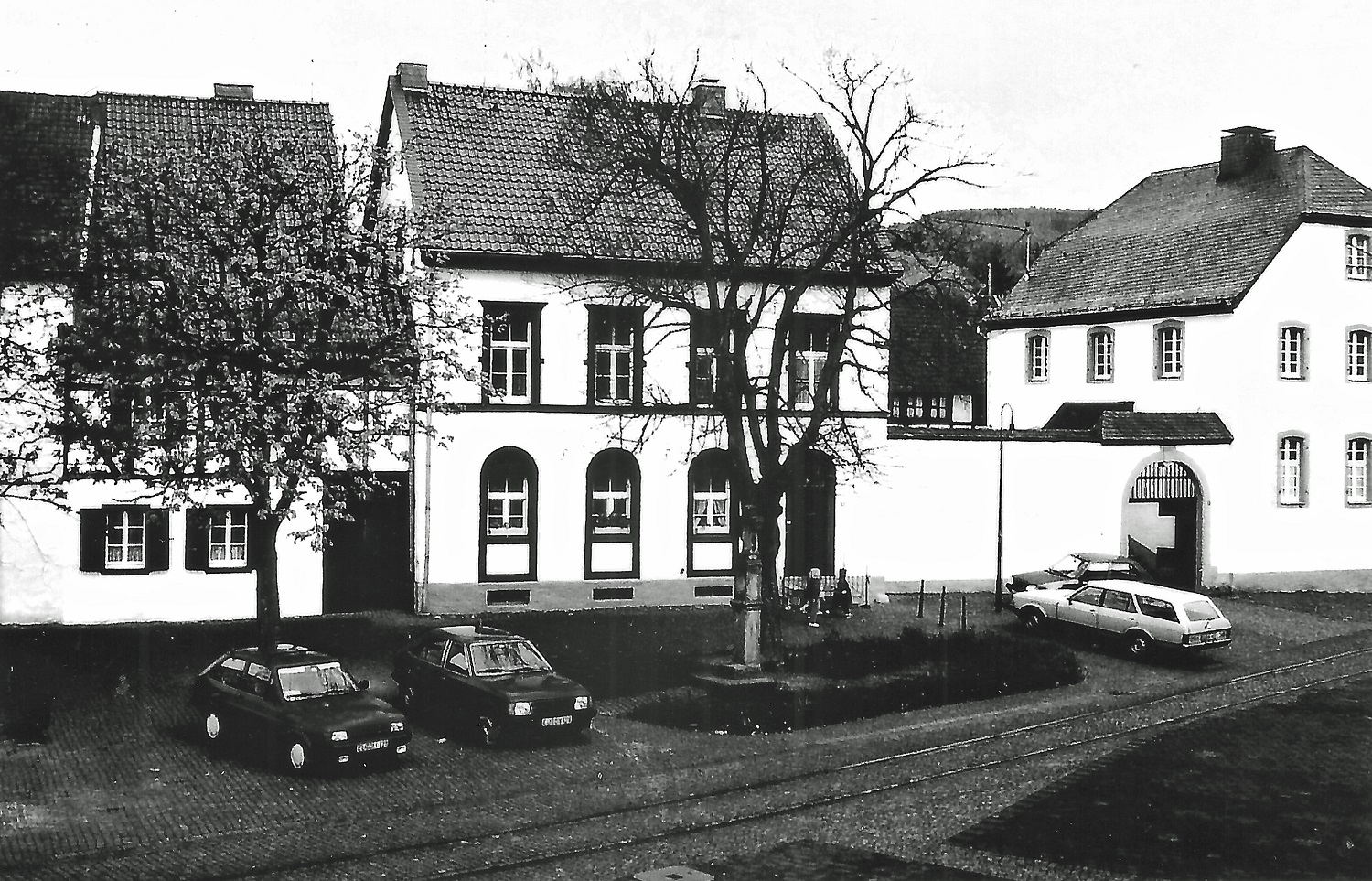 Das mittlere Gebäude, unmittelbar am Dorfplatz gelegen, wurde in den Jahren 1834/35 als erste Olefer Dorfschule errichtet und als solche bis 1926 genutzt. Nach einer grundlegenden Sanierung in den 1980er Jahren erstrahlt das heutige Wohnhaus in neuem Glanz.