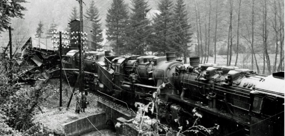 Die Abbildung zeigt die Unfallstelle zwischen Urft  und  Burg  Dalbenden  im  Jahre  1949:  Man  sieht  links  im  Bild  das  Gewirr  der  zer-trümmerten Koksgüter-wagen, davor die bei-den  Zuglokomotiven  des  Kokstransportes  in  Richtung  Trier,  rechts  die  führende  Lok  des  Zuges aus Ehrang. 