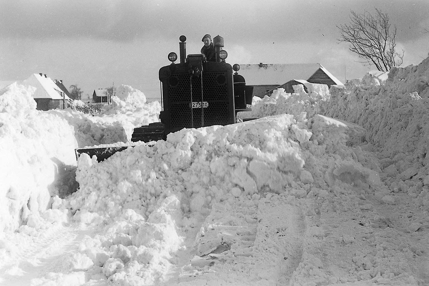 Ein belgischer Caterpillar des Camps Vogelsang räumt den Schnee von der Straße.