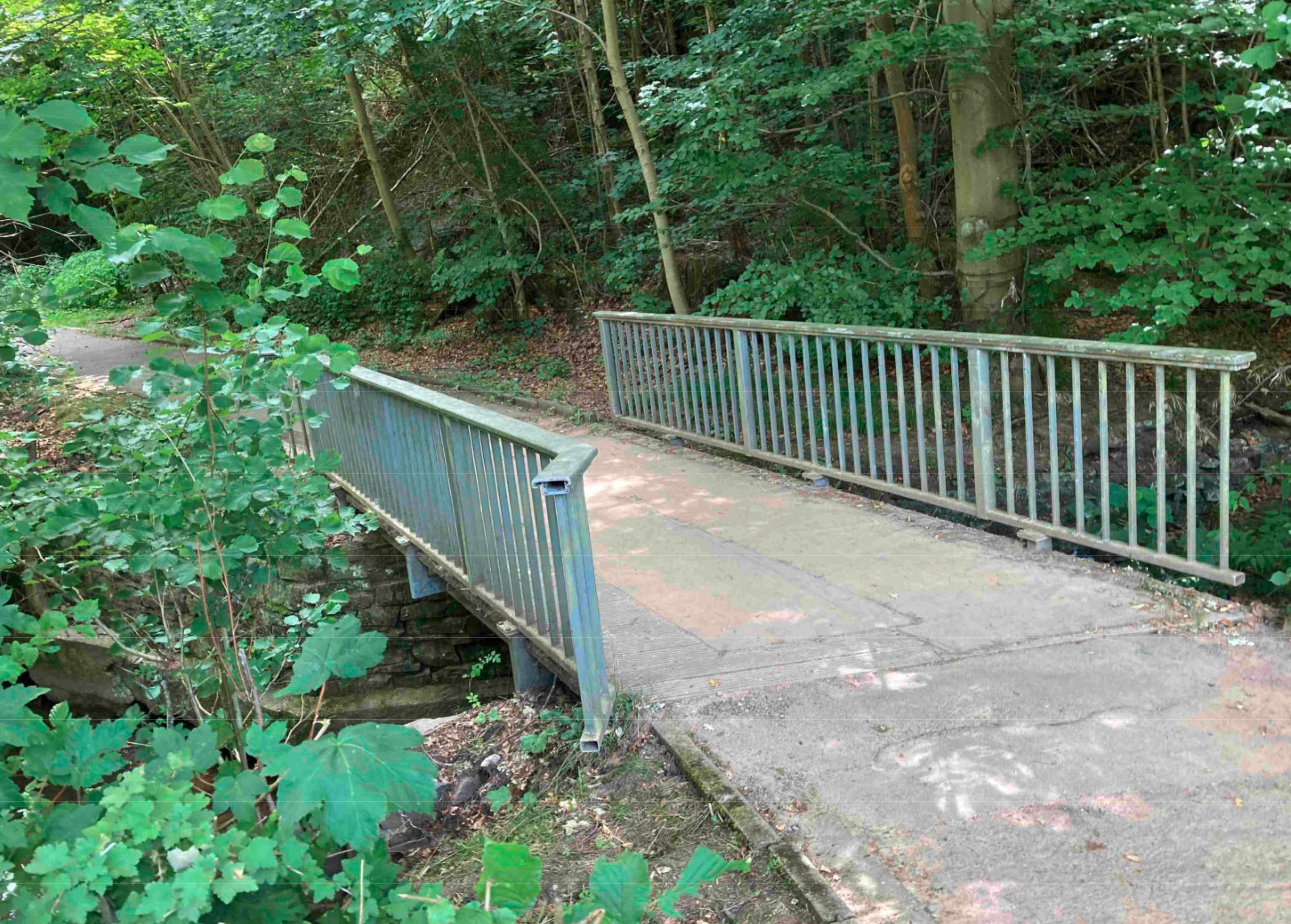 Fußgängerbrücke über den Dieffenbach in Schleiden, Kurpark / Freibad. Fußgängerbrücke über den Dieffenbach in Schleiden, Kurpark / Freibad.