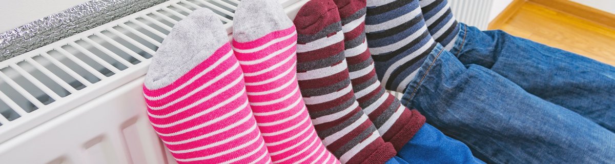 Füße werden an einem Heizkörper gewärmt.