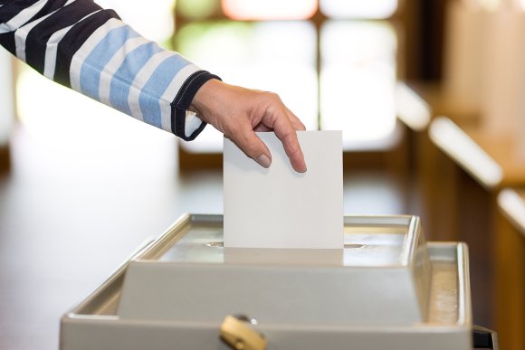 Stimmzettel in Wahlurne.