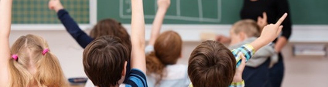 Schüler in der Grundschule zeigen auf